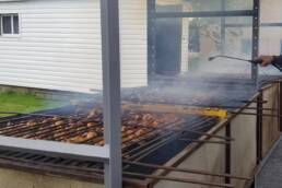 man working outside on chicken BBQ